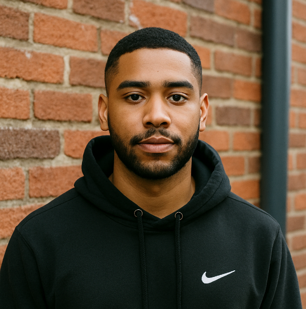 Man wearing a black Nike hoodie in front of a brick wall